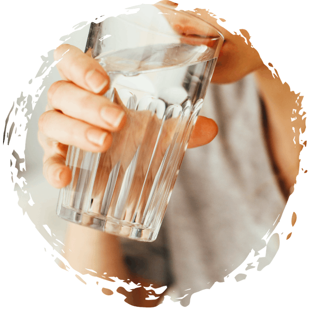 A women holding the glass and drinking the water